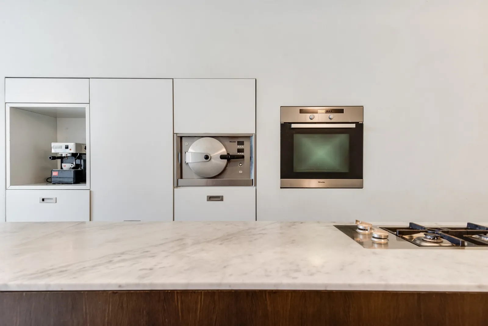 Keuken met een marmeren eiland en ingebouwde toestellen