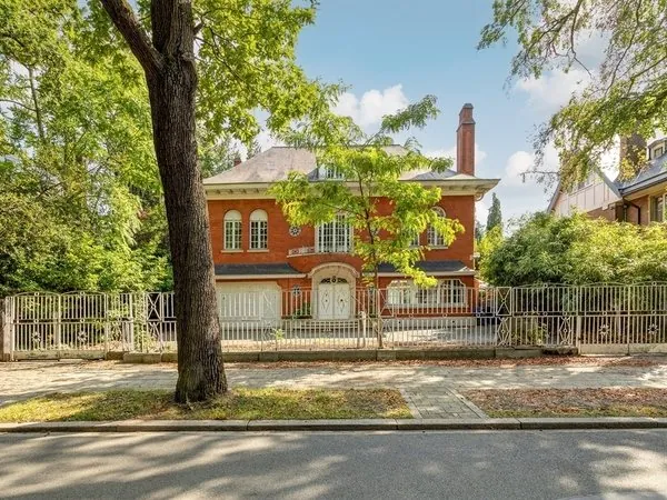 Bakstenen villa achter een groot park