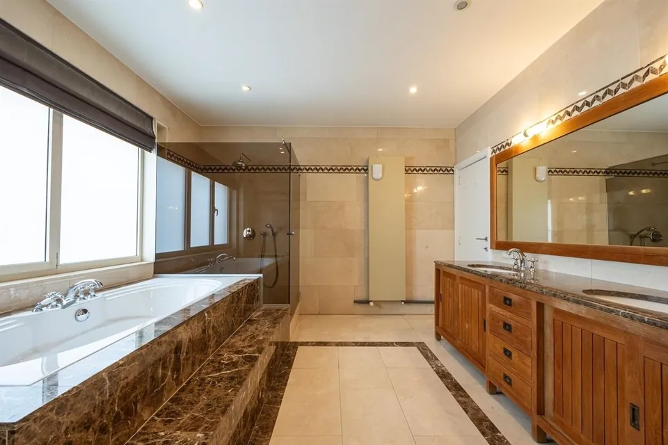 Badkamer in marmer met ligbad en dubbele lavabo