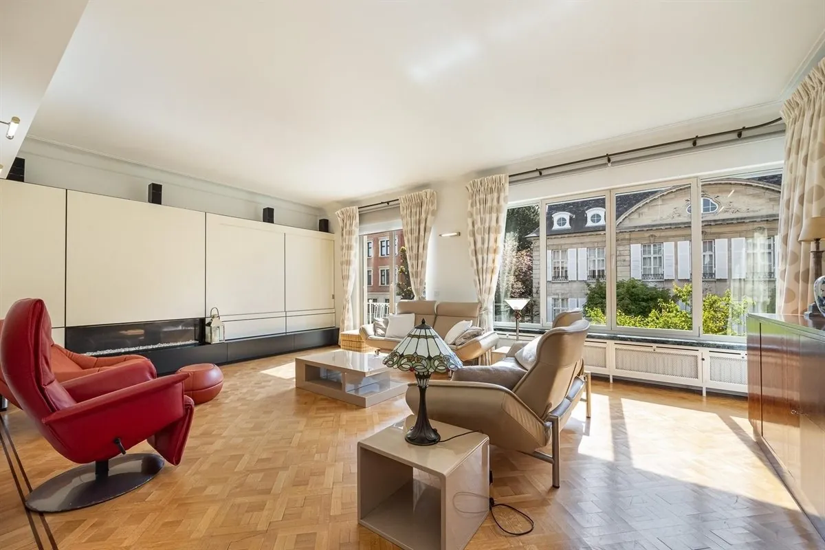 Zonnige leefkamer met parket, kastenwand en grote ramen